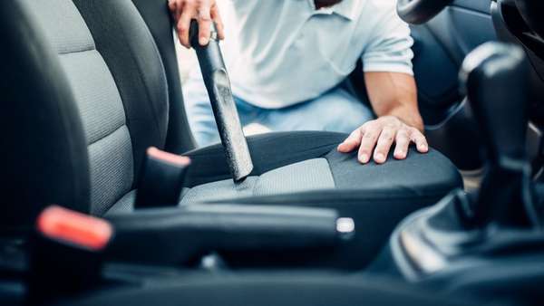 Close-up of car seat being vacuum cleaned